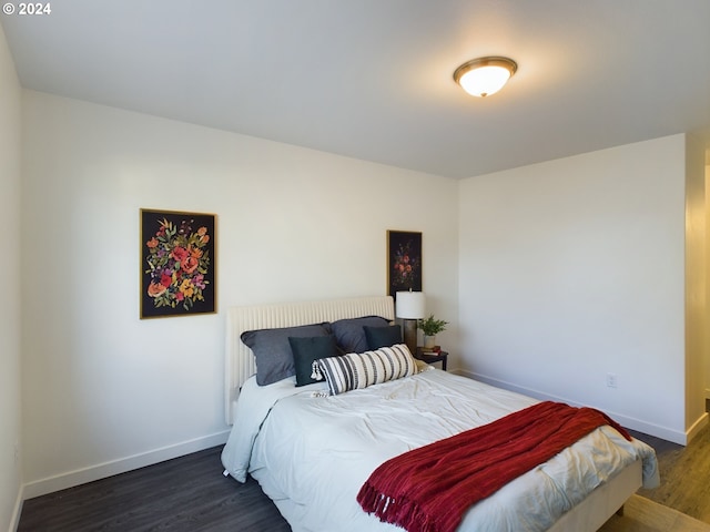 bedroom with wood finished floors and baseboards