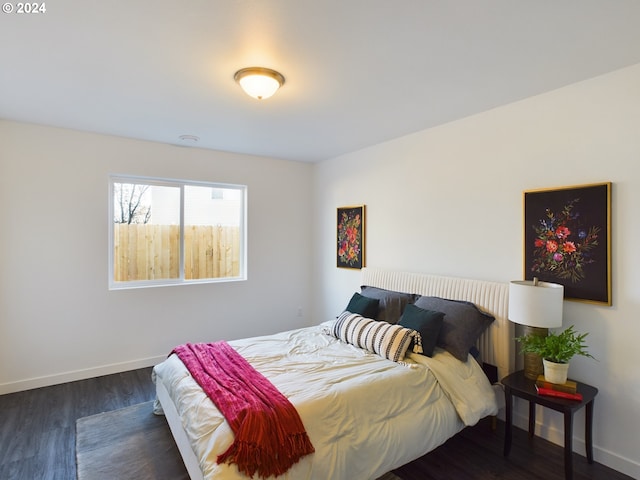 bedroom with dark wood finished floors and baseboards