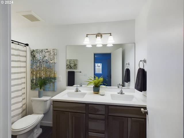 full bathroom with a sink, visible vents, toilet, and double vanity