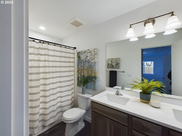 bathroom featuring visible vents, curtained shower, toilet, and vanity