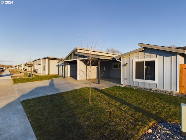 view of front facade featuring a front yard, board and batten siding, and driveway