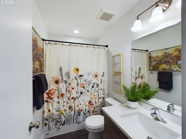 bathroom featuring visible vents, toilet, and vanity