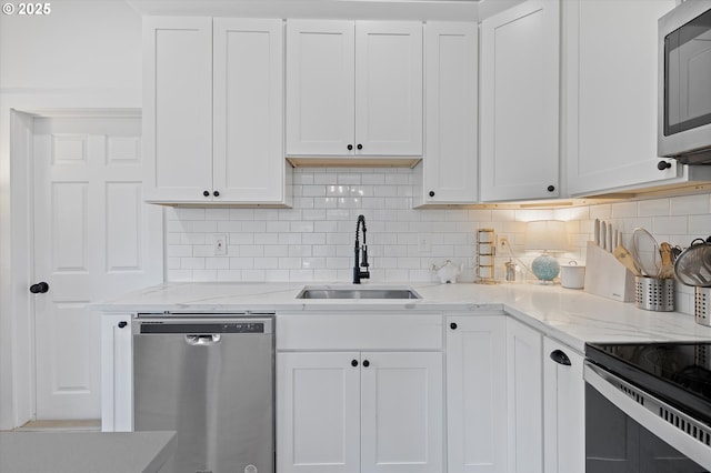 8007 N Hudson St, Portland, OR 97203 - kitchen featuring stainless steel appliances, white cabinetry, decorative backsplash, and light stone countertops