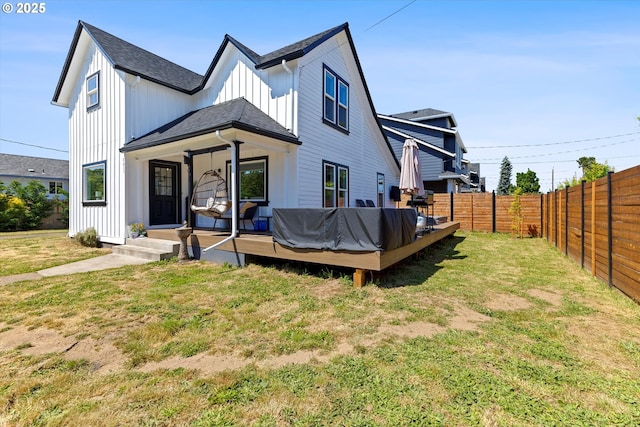 8007 N Hudson St, Portland, OR 97203 - back of property with board and batten siding, a fenced backyard, a wooden deck, and a shingled roof
