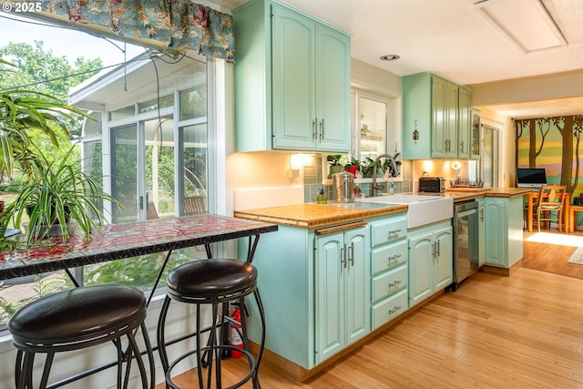 855 E 39th Ave, Eugene, OR 97405 - kitchen featuring stainless steel dishwasher, green cabinetry, a sink, light wood-type flooring, and recessed lighting