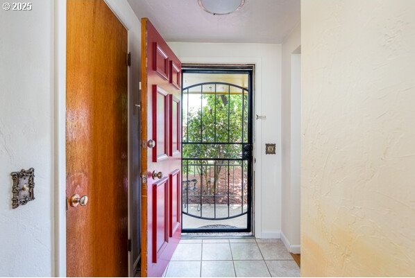 855 E 39th Ave, Eugene, OR 97405 - entryway featuring light tile patterned floors, a textured wall, and baseboards