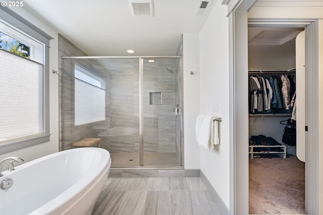 19294 Boulder Run Ct, Oregon City, OR 97045 - full bathroom featuring a freestanding tub, a walk in closet, a shower stall, recessed lighting, and marble look tiles