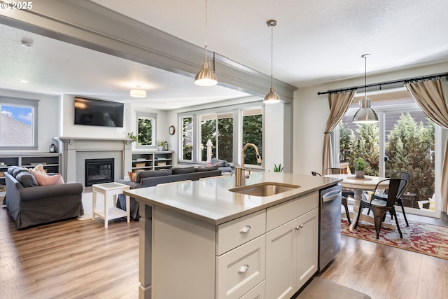 19294 Boulder Run Ct, Oregon City, OR 97045 - kitchen featuring light wood-style flooring, hanging light fixtures, light countertops, and stainless steel dishwasher