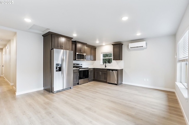 21190 SW Ortiz Ln, Beaverton, OR 97003 - kitchen featuring dark brown cabinetry, a wall unit AC, light wood-type flooring, and appliances with stainless steel finishes