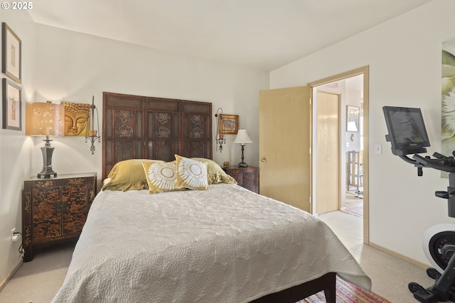 bedroom with light colored carpet and baseboards
