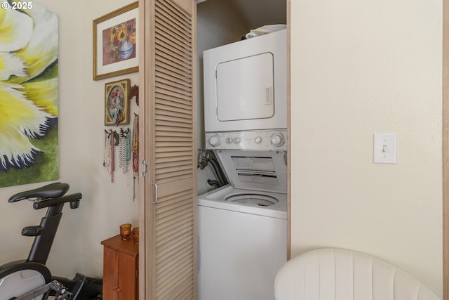 clothes washing area with stacked washer / dryer