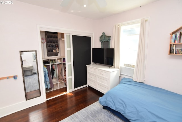 bedroom with cooling unit, a ceiling fan, and dark wood-type flooring