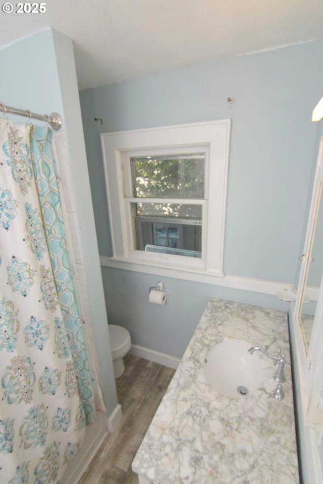 bathroom with vanity, wood finished floors, toilet, and a shower with curtain