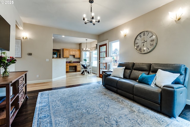 living room with dark hardwood / wood-style flooring and a notable chandelier