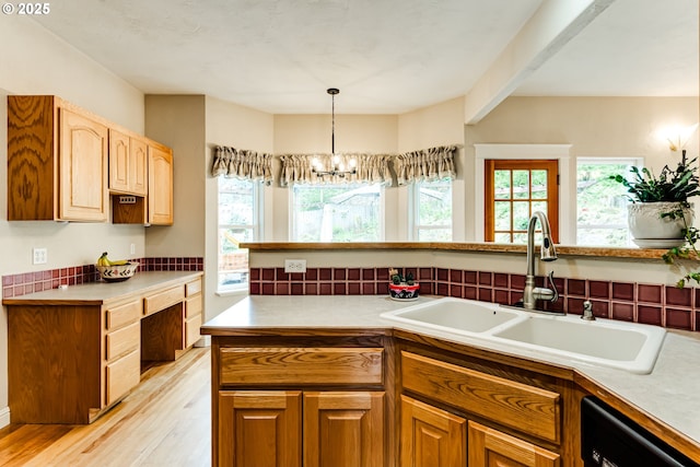 kitchen featuring sink, a chandelier, hanging light fixtures, light wood-type flooring, and dishwasher