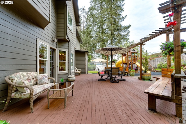 wooden terrace featuring an outdoor hangout area, a pergola, and a playground