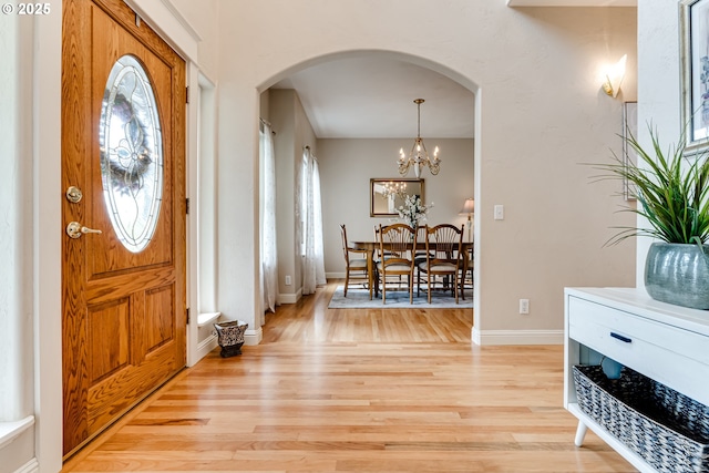 foyer entrance featuring a chandelier and light hardwood / wood-style flooring