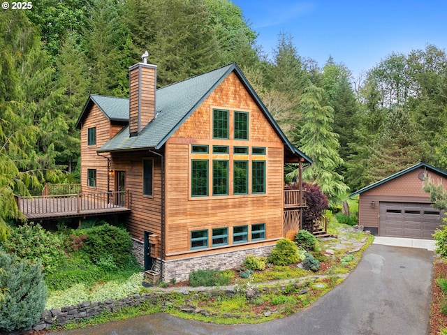 33901 Merrill Creek Rd, Deer Island, OR 97054 - view of front of house featuring a chimney, a wooded view, a garage, and an outdoor structure