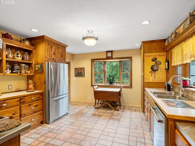 33901 Merrill Creek Rd, Deer Island, OR 97054 - kitchen featuring appliances with stainless steel finishes, a sink, brown cabinets, light countertops, and baseboards