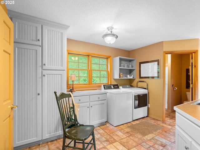 33901 Merrill Creek Rd, Deer Island, OR 97054 - laundry room featuring cabinet space, independent washer and dryer, a textured ceiling, and stone finish floors