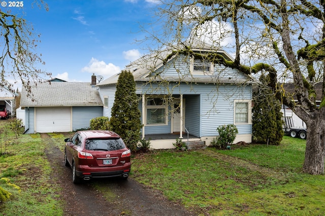 bungalow-style home featuring a garage and a front lawn