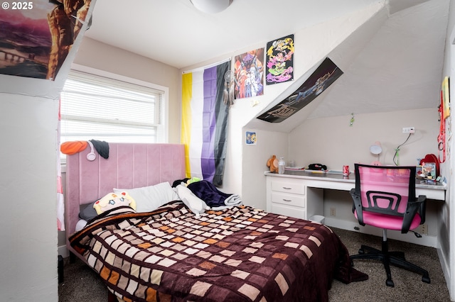 carpeted bedroom featuring built in desk and lofted ceiling