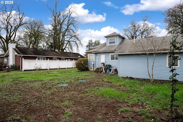 rear view of property featuring a lawn