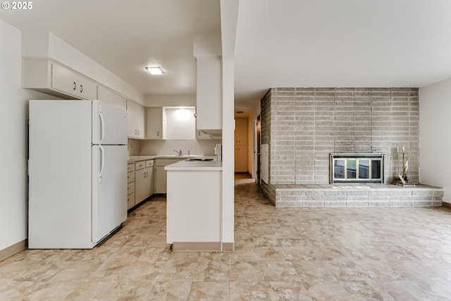 495 W 27th Ave, Eugene, OR 97405 - kitchen featuring freestanding refrigerator, a fireplace, light countertops, a sink, and white cabinets