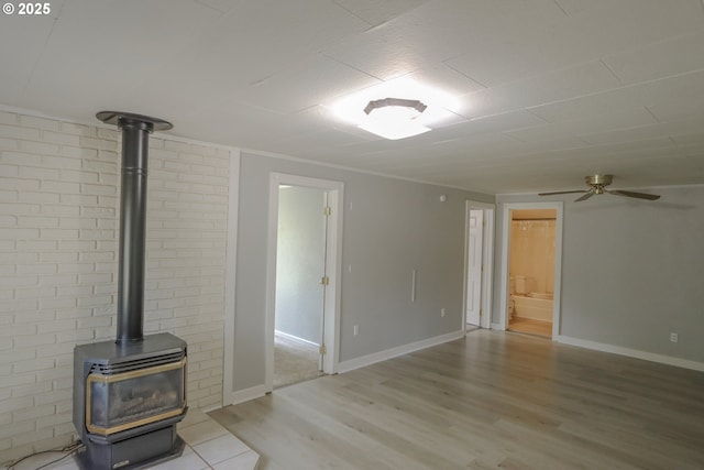 58798 Fairview Rd, Coquille, OR 97423 - unfurnished living room with a wood stove, light wood-style floors, a ceiling fan, and baseboards