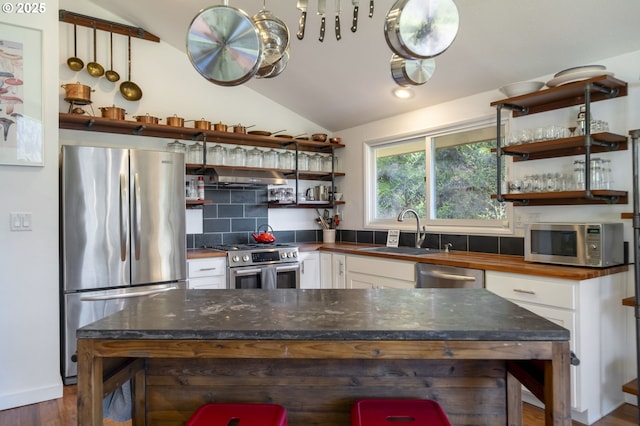 49867 Hills Creek Rd, Oakridge, OR 97463 - kitchen with open shelves, a sink, stainless steel appliances, under cabinet range hood, and vaulted ceiling