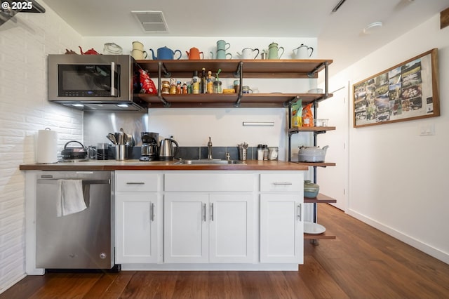 49867 Hills Creek Rd, Oakridge, OR 97463 - bar featuring appliances with stainless steel finishes, visible vents, dark wood-style floors, and a sink