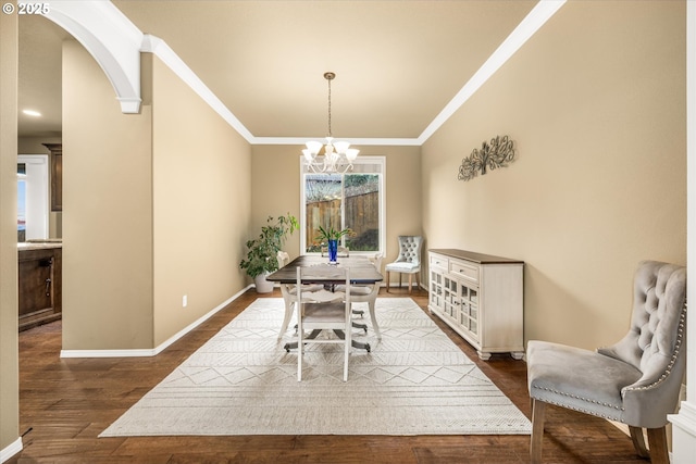 dining space featuring arched walkways, crown molding, a notable chandelier, dark wood finished floors, and baseboards