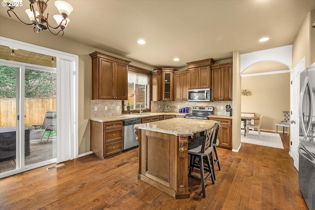 kitchen featuring dark wood-style floors, stainless steel appliances, a sink, and visible vents