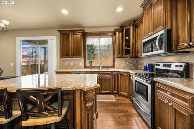 kitchen with a breakfast bar, a healthy amount of sunlight, stainless steel appliances, and a sink