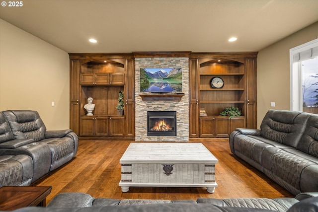 living area with a fireplace, wood finished floors, and recessed lighting