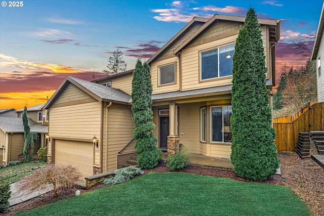 view of front of house featuring a garage, fence, and a front yard