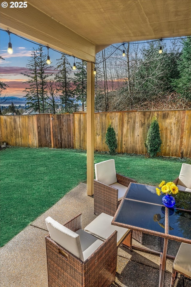 patio terrace at dusk with fence and a yard