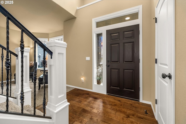 entrance foyer featuring dark wood-style floors, stairs, and baseboards