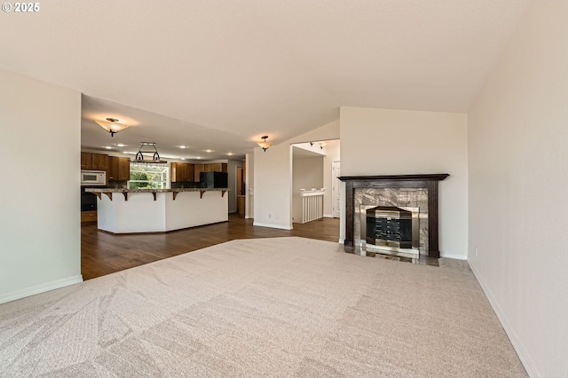 15911 NE 29th Ave, Ridgefield, WA 98642 - unfurnished living room with dark carpet, recessed lighting, lofted ceiling, a fireplace, and dark wood-style floors
