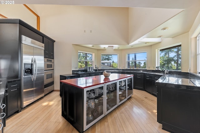 34700 Hill St, Pacific City, OR 97135 - kitchen featuring dark cabinetry, built in refrigerator, healthy amount of natural light, and light wood-type flooring