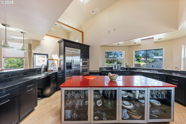 34700 Hill St, Pacific City, OR 97135 - kitchen with stainless steel appliances, dark cabinetry, a sink, and light wood-style floors
