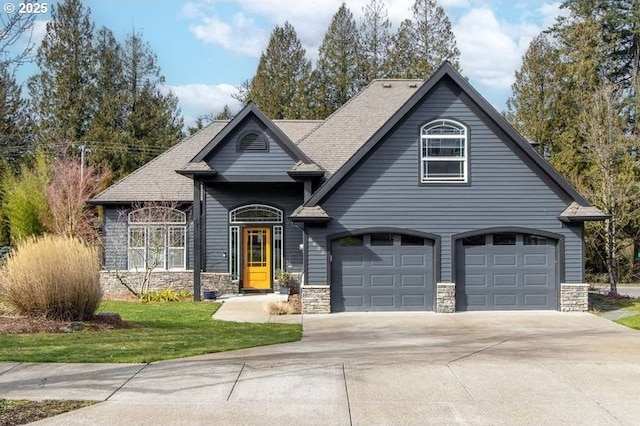 view of front facade with a garage, stone siding, a front lawn, and driveway