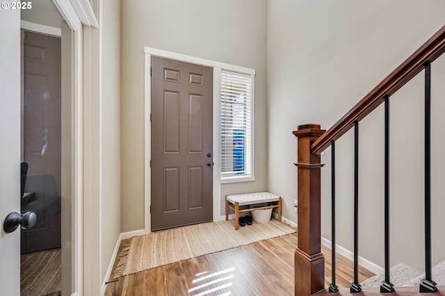 entrance foyer featuring baseboards, stairway, and wood finished floors