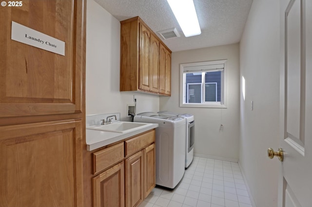 clothes washing area with independent washer and dryer, a textured ceiling, cabinets, light tile patterned flooring, and sink