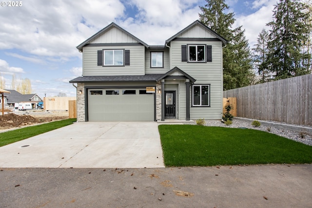 craftsman inspired home with fence, concrete driveway, board and batten siding, a front yard, and a garage
