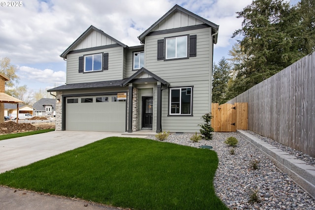 view of front of property with concrete driveway, board and batten siding, an attached garage, fence, and a front yard