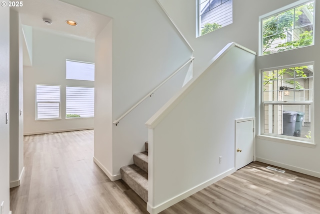 2370 NE 12th Way, Hillsboro, OR 97124 - stairs with healthy amount of natural light, wood finished floors, a towering ceiling, baseboards, and recessed lighting