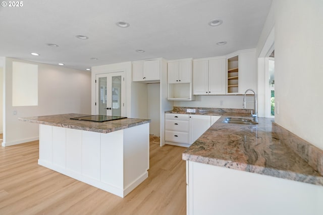 6195 Pear Tree Ln SE, Salem, OR 97317 - kitchen featuring black electric stovetop, light wood-style floors, a kitchen island, white cabinets, and recessed lighting