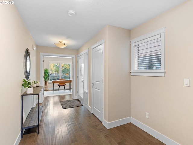 entrance foyer featuring baseboards and dark wood finished floors