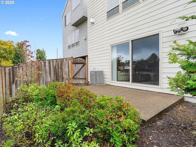 exterior space with fence, central AC, and a gate